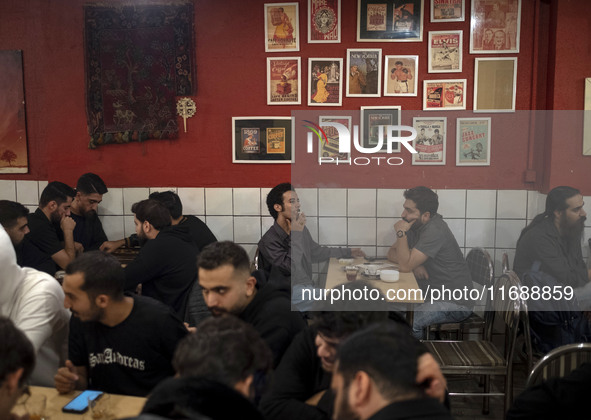 A young Iranian man smokes a cigarette at a cafe at night in the historical city of Tabriz, Iran, on October 18, 2024, amid global concerns...