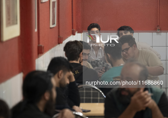 A young Iranian man smokes a cigarette at a cafe at night in the historical city of Tabriz, Iran, on October 18, 2024, amid global concerns...