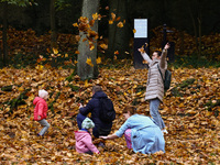 People play throwing leaves on an autumn day at Bednarski Park n Krakow, Poland on October 20th, 2024. (