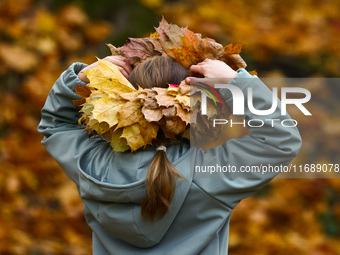 A girls wears a wreath of leaves on a sunny autumn day at Bednarski Park in Krakow, Poland on October 20th, 2024. (