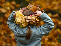 A girls wears a wreath of leaves on a sunny autumn day at Bednarski Park in Krakow, Poland on October 20th, 2024. (