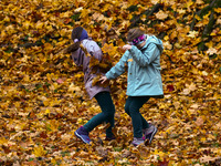 Children play throwing leaves on an autumn day at Bednarski Park n Krakow, Poland on October 20th, 2024. (