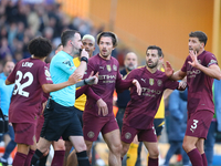 Manchester players await a VAR decision relating to their second goal during the Premier League match between Wolverhampton Wanderers and Ma...