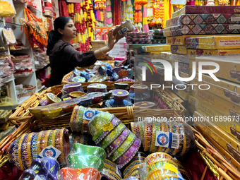 A woman shops for diyas (decorative earthen lamps) and Diwali decorations at a shop selling puja items in preparation for the festival of Di...