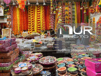 People shop for diyas (decorative earthen lamps) and Diwali decorations at a shop selling puja items in preparation for the festival of Diwa...