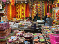 People shop for diyas (decorative earthen lamps) and Diwali decorations at a shop selling puja items in preparation for the festival of Diwa...