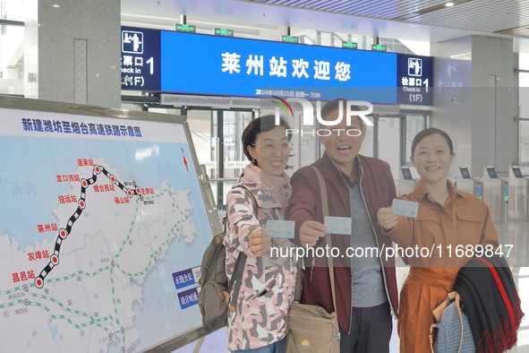 Passengers take the first train of the Weifang High-Speed Railway and pose for a group photo at Laizhou Railway Station in Yantai, China, on...