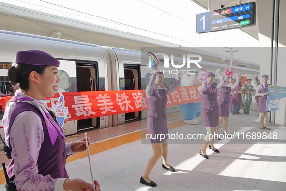 Railway workers promote cultural tourism at Laizhou Railway Station in Yantai, China, on October 21, 2024. 