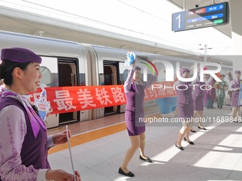 Railway workers promote cultural tourism at Laizhou Railway Station in Yantai, China, on October 21, 2024. (