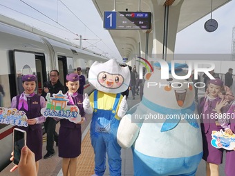 Railway workers promote cultural tourism at Laizhou Railway Station in Yantai, China, on October 21, 2024. (