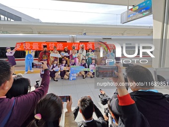 Railway workers promote cultural tourism at Laizhou Railway Station in Yantai, China, on October 21, 2024. (