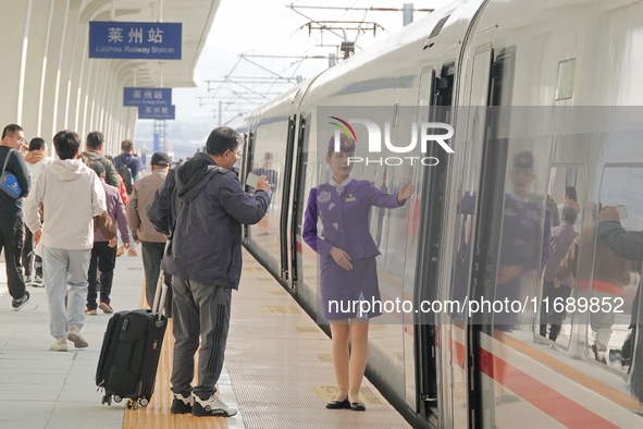 Passengers travel on the first train of the Weifang-Yantai High-Speed Railway at Laizhou Railway Station in Yantai, China, on October 21, 20...