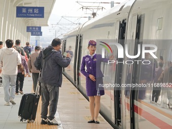 Passengers travel on the first train of the Weifang-Yantai High-Speed Railway at Laizhou Railway Station in Yantai, China, on October 21, 20...