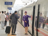 Passengers travel on the first train of the Weifang-Yantai High-Speed Railway at Laizhou Railway Station in Yantai, China, on October 21, 20...