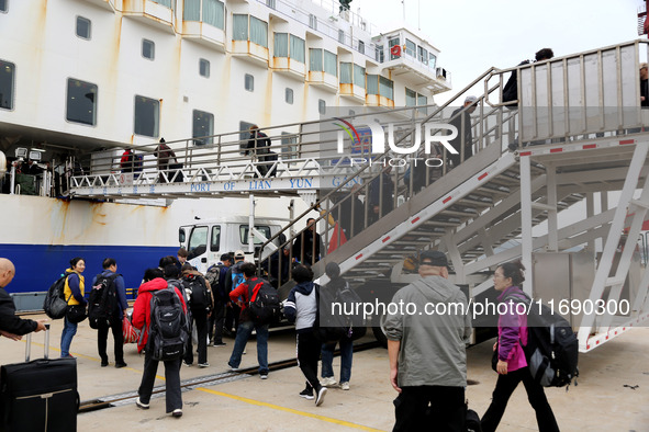 Passengers board a ferry after customs clearance at Lianyungang International Passenger Station in Lianyungang, China, on October 21, 2024....