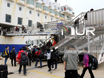 Passengers board a ferry after customs clearance at Lianyungang International Passenger Station in Lianyungang, China, on October 21, 2024....