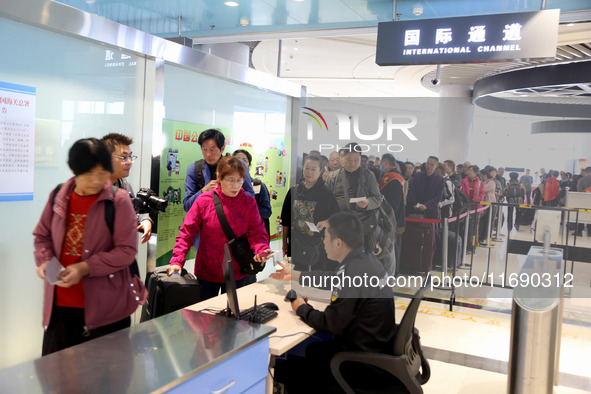 Passengers board a ferry after customs clearance at Lianyungang International Passenger Station in Lianyungang, China, on October 21, 2024....