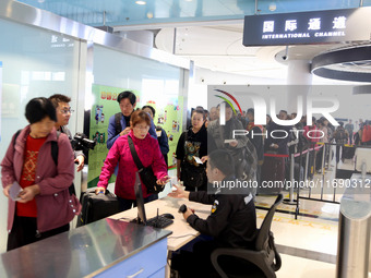 Passengers board a ferry after customs clearance at Lianyungang International Passenger Station in Lianyungang, China, on October 21, 2024....