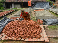 A lady dries clay pots, which are made for sale ahead of the Diwali festival celebration in Kolkata, India, on October 21, 2024. (