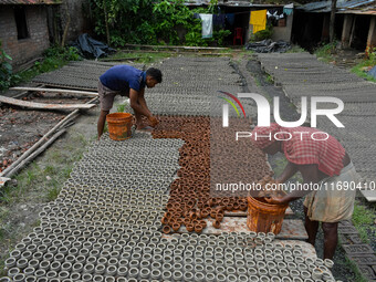 Workers dry clay pots, which are made for sale ahead of the Diwali festival celebration in Kolkata, India, on October 21, 2024. (