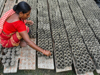 A lady dries clay pots, which are made for sale ahead of the Diwali festival celebration in Kolkata, India, on October 21, 2024. (