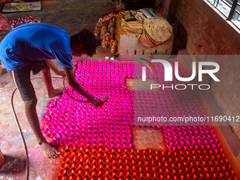 Workers apply colors to clay oil lamps, which are made for sale ahead of the Diwali festival celebration in Kolkata, India, on October 21, 2...