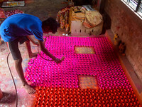 Workers apply colors to clay oil lamps, which are made for sale ahead of the Diwali festival celebration in Kolkata, India, on October 21, 2...