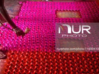 Workers apply colors to clay oil lamps, which are made for sale ahead of the Diwali festival celebration in Kolkata, India, on October 21, 2...