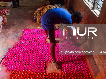 Workers apply colors to clay oil lamps, which are made for sale ahead of the Diwali festival celebration in Kolkata, India, on October 21, 2...