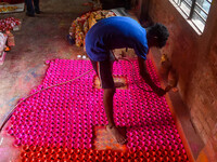 Workers apply colors to clay oil lamps, which are made for sale ahead of the Diwali festival celebration in Kolkata, India, on October 21, 2...