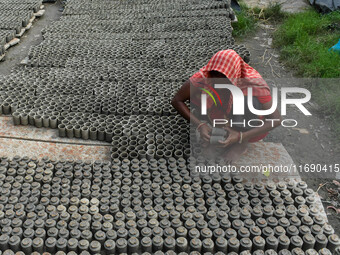 A lady dries clay pots, which are made for sale ahead of the Diwali festival celebration in Kolkata, India, on October 21, 2024. (