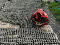 A lady dries clay pots, which are made for sale ahead of the Diwali festival celebration in Kolkata, India, on October 21, 2024. (