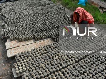 A lady dries clay pots, which are made for sale ahead of the Diwali festival celebration in Kolkata, India, on October 21, 2024. (