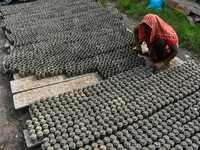 A lady dries clay pots, which are made for sale ahead of the Diwali festival celebration in Kolkata, India, on October 21, 2024. (