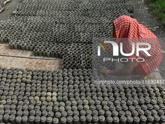 A lady dries clay pots, which are made for sale ahead of the Diwali festival celebration in Kolkata, India, on October 21, 2024. (