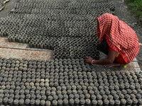 A lady dries clay pots, which are made for sale ahead of the Diwali festival celebration in Kolkata, India, on October 21, 2024. (