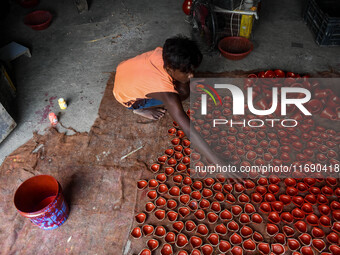 Workers apply final touches to clay oil lamps, which are made for sale ahead of the Diwali festival celebration in Kolkata, India, on Octobe...