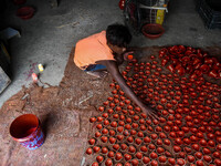 Workers apply final touches to clay oil lamps, which are made for sale ahead of the Diwali festival celebration in Kolkata, India, on Octobe...