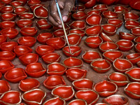 Workers apply final touches to clay oil lamps, which are made for sale ahead of the Diwali festival celebration in Kolkata, India, on Octobe...