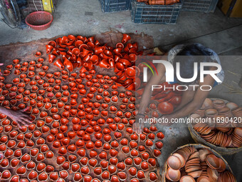 Workers apply final touches to clay oil lamps, which are made for sale ahead of the Diwali festival celebration in Kolkata, India, on Octobe...