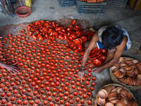 Workers apply final touches to clay oil lamps, which are made for sale ahead of the Diwali festival celebration in Kolkata, India, on Octobe...