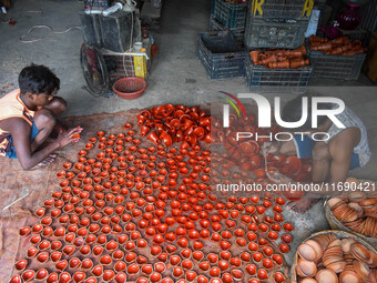 Workers apply final touches to clay oil lamps, which are made for sale ahead of the Diwali festival celebration in Kolkata, India, on Octobe...