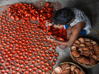 Workers apply final touches to clay oil lamps, which are made for sale ahead of the Diwali festival celebration in Kolkata, India, on Octobe...