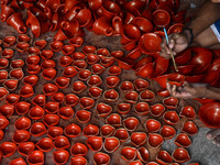 Workers apply final touches to clay oil lamps, which are made for sale ahead of the Diwali festival celebration in Kolkata, India, on Octobe...