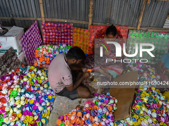 Workers apply final touches to clay oil lamps, which are made for sale ahead of the Diwali festival celebration in Kolkata, India, on Octobe...