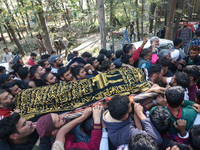 People carry the dead body of a doctor who is killed in an alleged militant attack in the Nadigam area of Budgam district, Indian-administer...