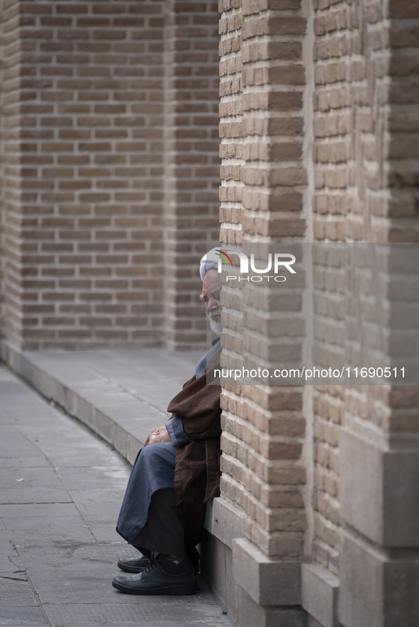 An Iranian cleric sits in front of a mosque outside a seminary in the historical city of Tabriz, located 624 km (388 miles) northwest of Teh...