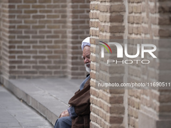 An Iranian cleric sits in front of a mosque outside a seminary in the historical city of Tabriz, located 624 km (388 miles) northwest of Teh...