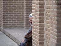 An Iranian cleric sits in front of a mosque outside a seminary in the historical city of Tabriz, located 624 km (388 miles) northwest of Teh...