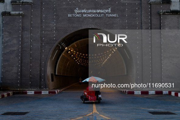 A seller with a colorful umbrella motorcycle cart enters Betong Mongkollit Tunnel in Betong, Yala Province, Thailand, on October 21, 2024. 